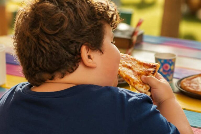 bambino obeso mangia pizza